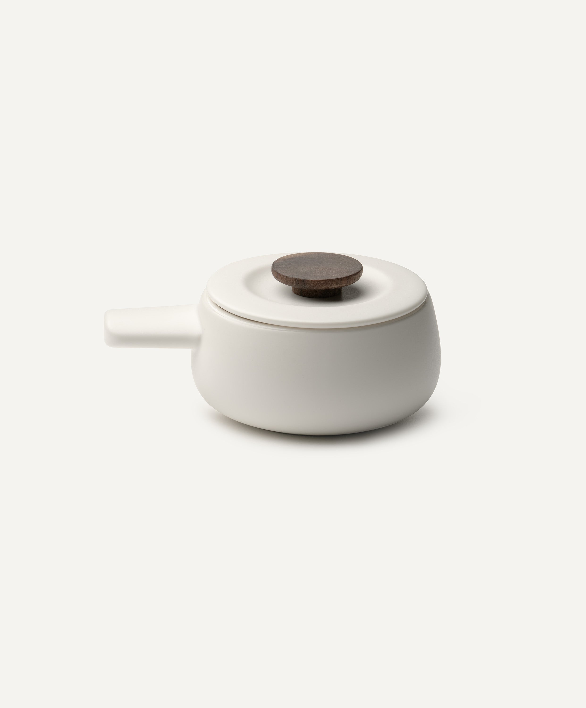 Fondi 7.6 fl oz / 225 mL self-heating ceramic fondue set in Jasmine White with lid charging on OHOM Pad 3