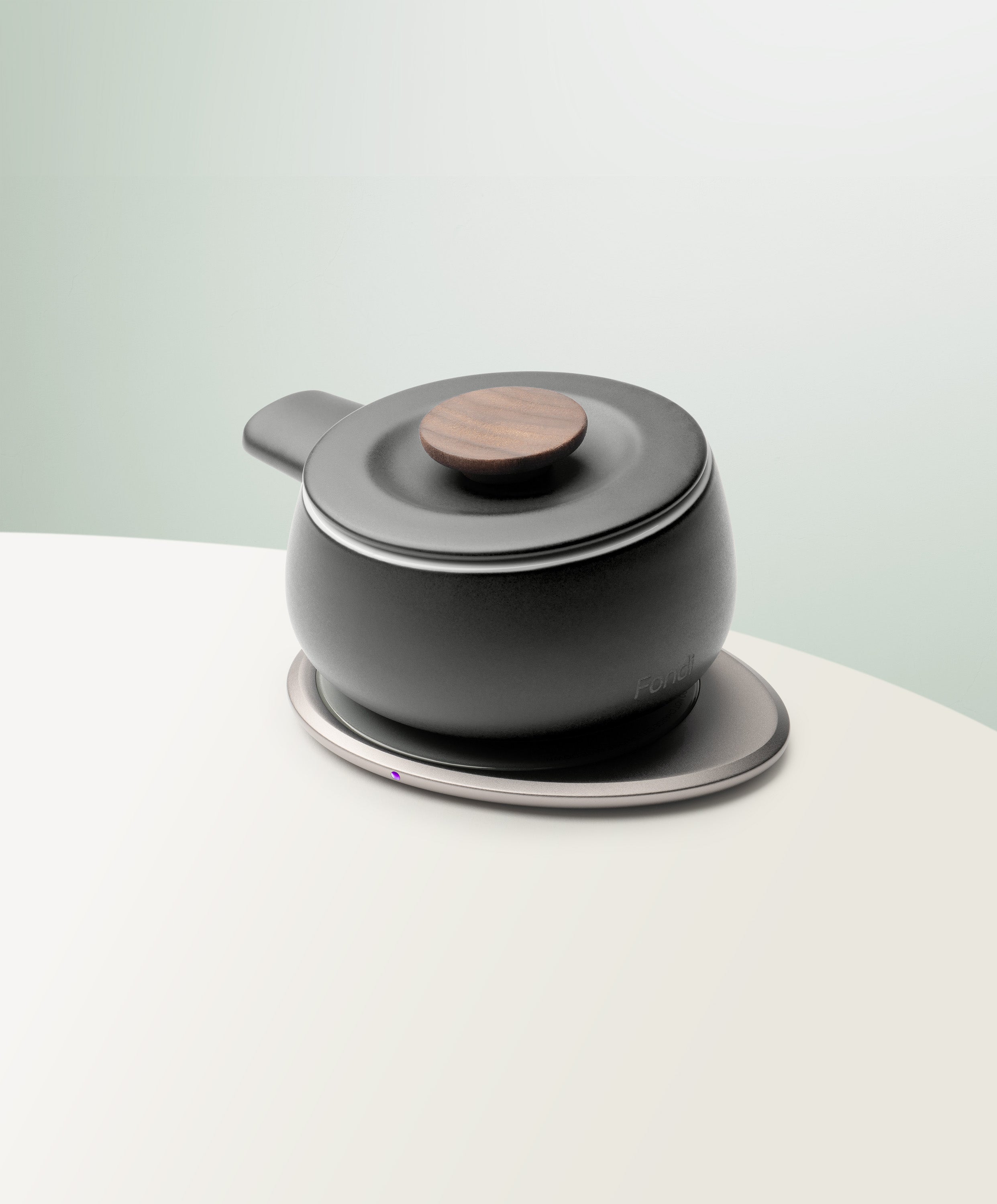 Fondi Self-Heating Ceramic Fondue 7.6 fl oz / 225 mL in Inkstone Black angled top-side view on OHOM Charging Pad 3