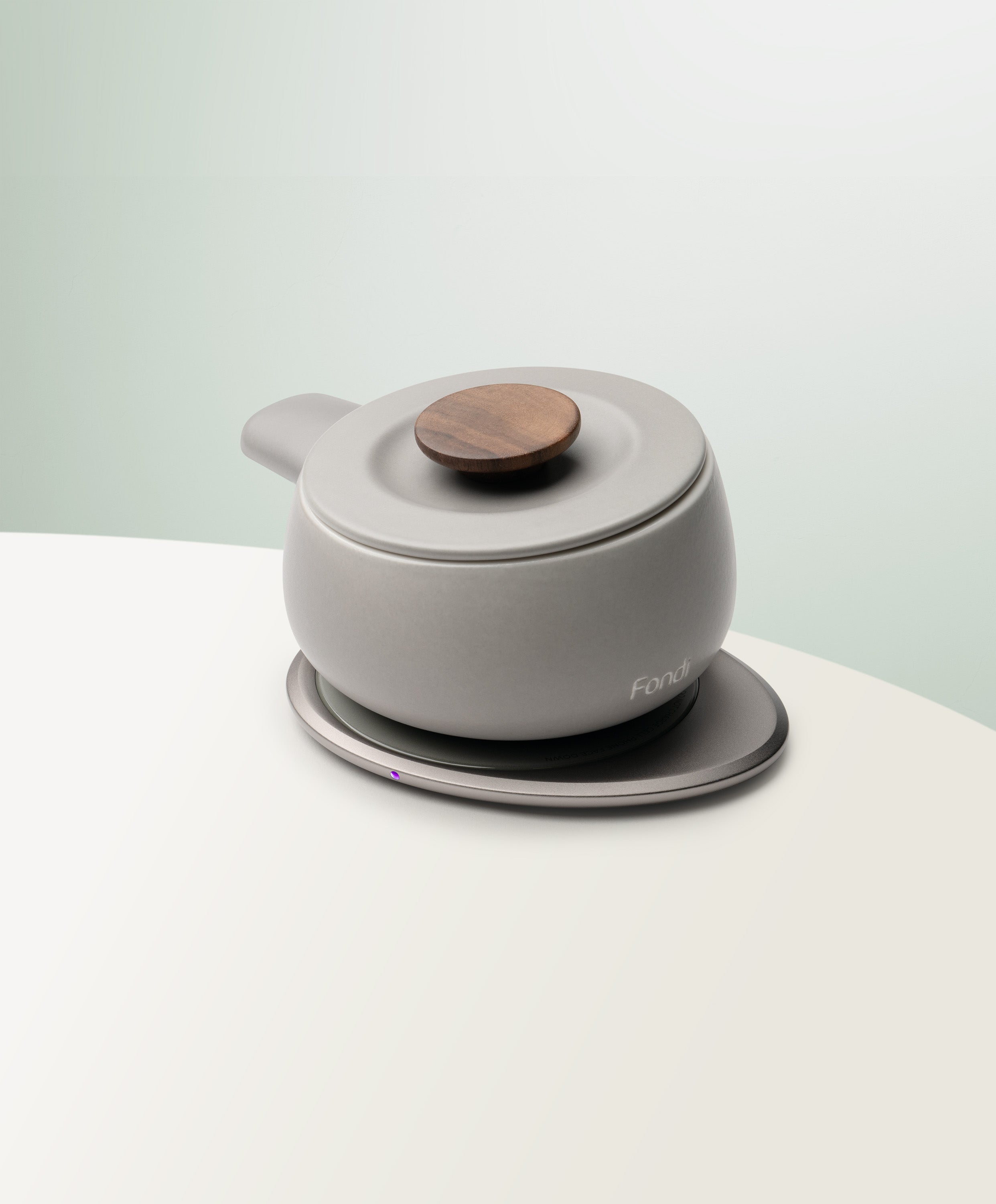 Fondi Self-Heating Ceramic Fondue 7.6 fl oz / 225 mL in Soft Gray angled top-side view on OHOM Charging Pad 3
