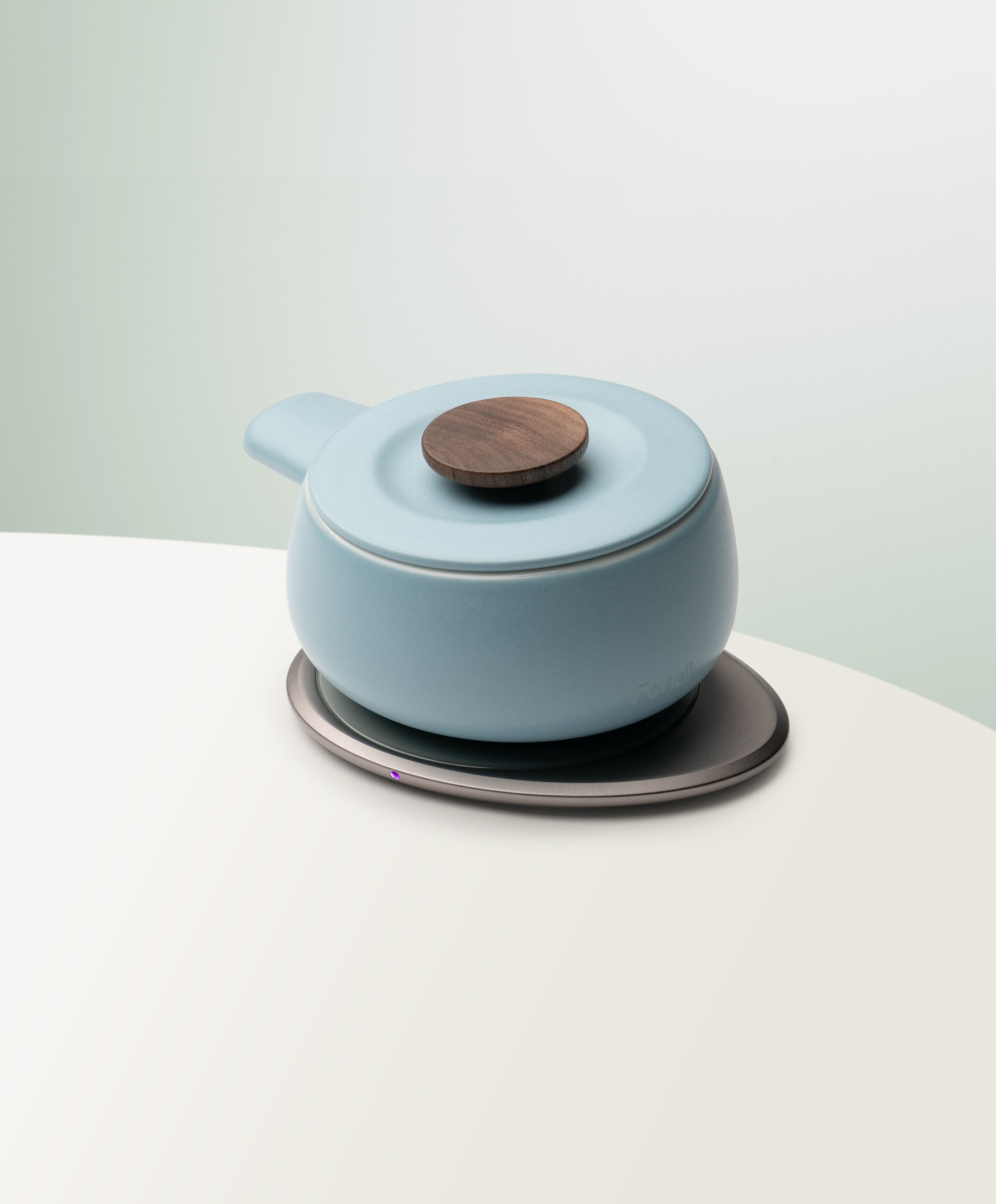 Fondi Self-Heating Ceramic Fondue 7.6 fl oz / 225 mL in Moonmist Blue angled top-side view on OHOM Charging Pad 3