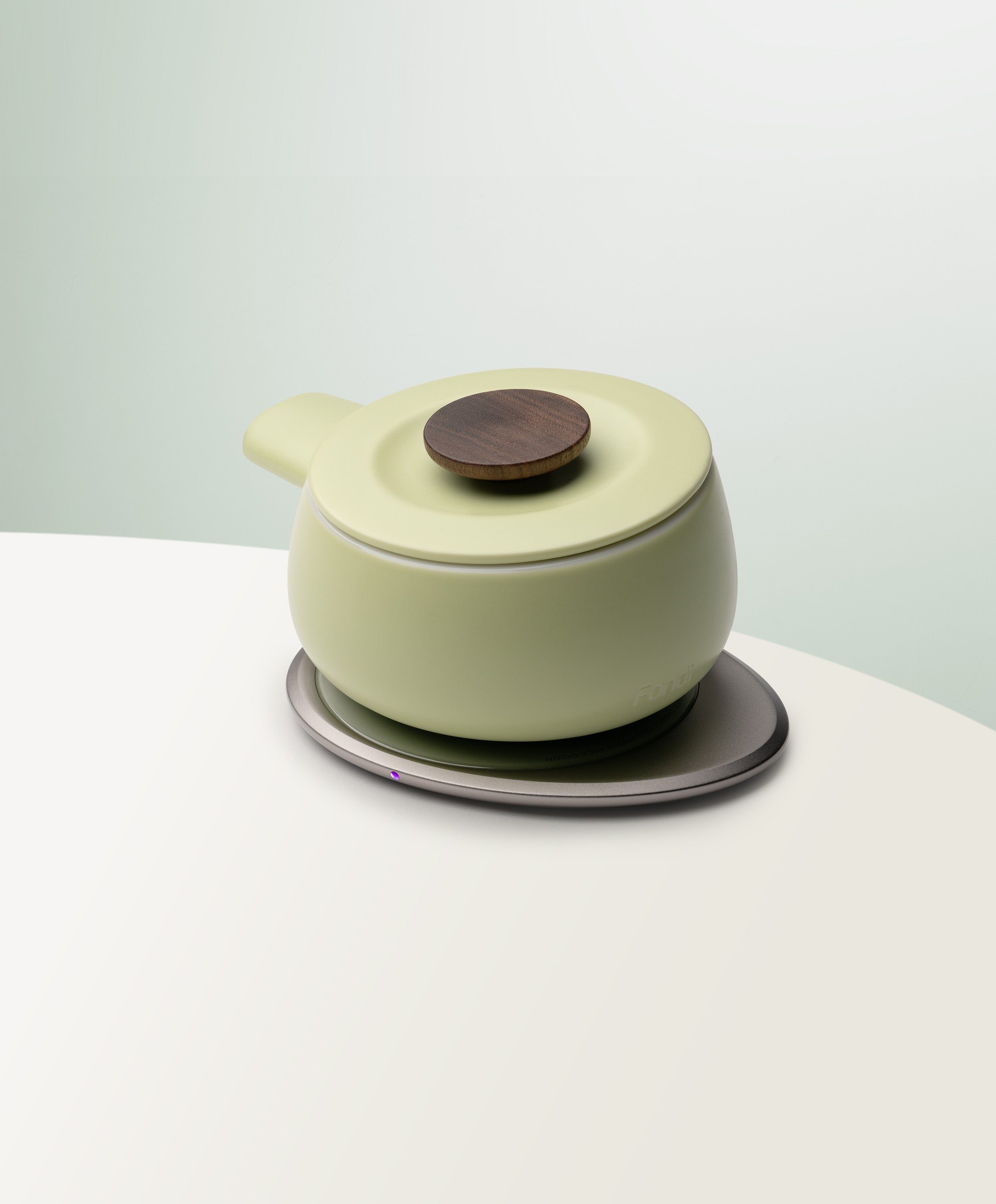 Fondi Self-Heating Ceramic Fondue 7.6 fl oz / 225 mL in Verde Green angled top-side view on OHOM Charging Pad 3