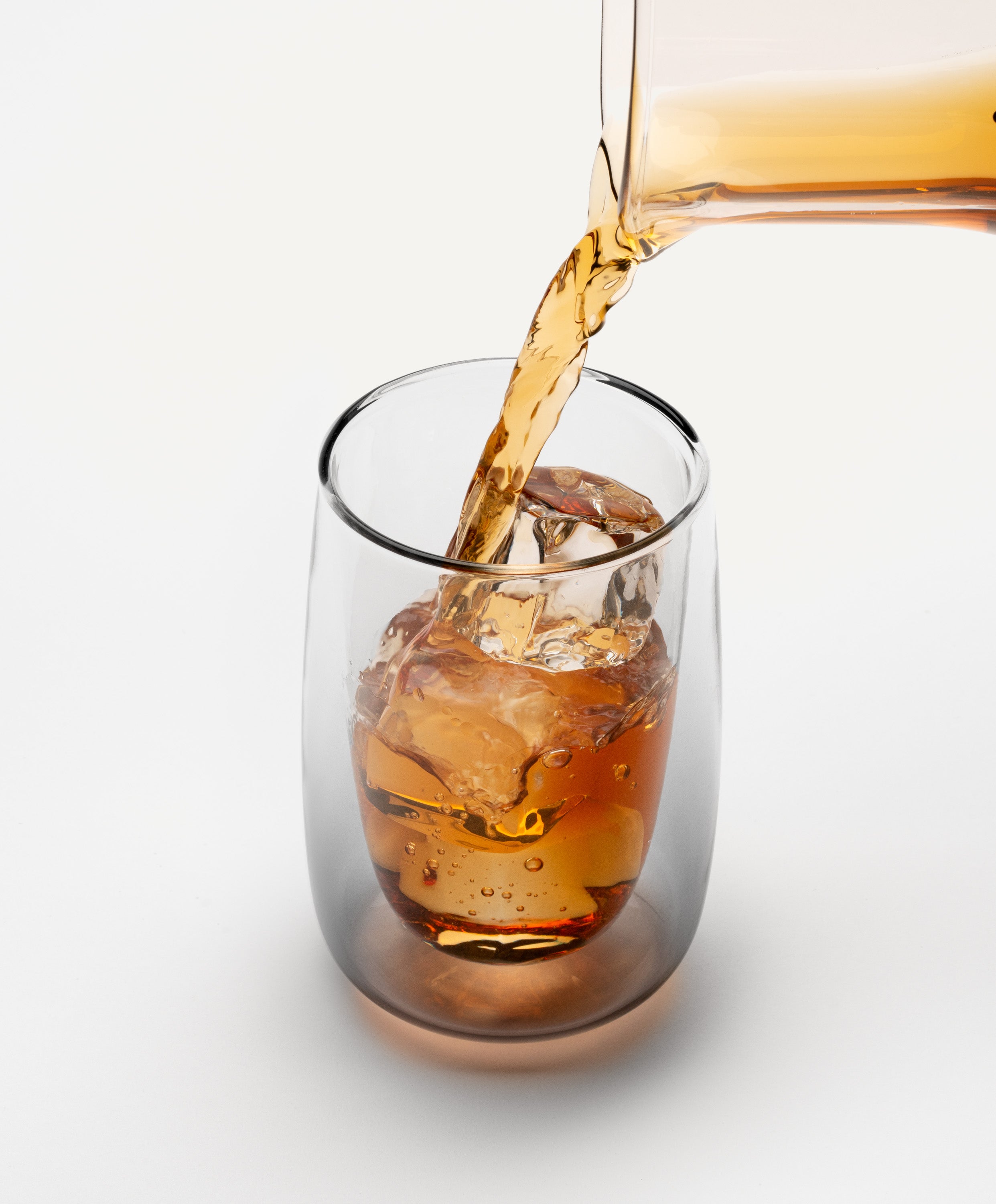 Pouring iced tea into Sio dual-wall glass 8 fl oz / 236 mL made from fine borosilicate glass, showing floating liquid effect