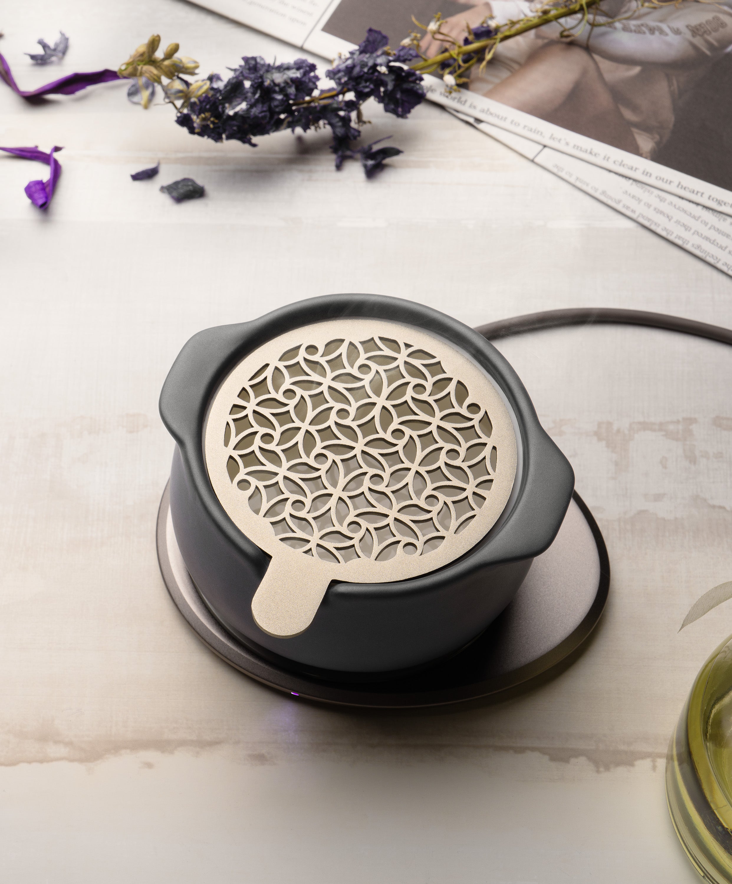Jun self-heating ceramic diffuser 5 fl oz / 150 mL in Inkstone Black with lid on charging on OHOM Pad 3