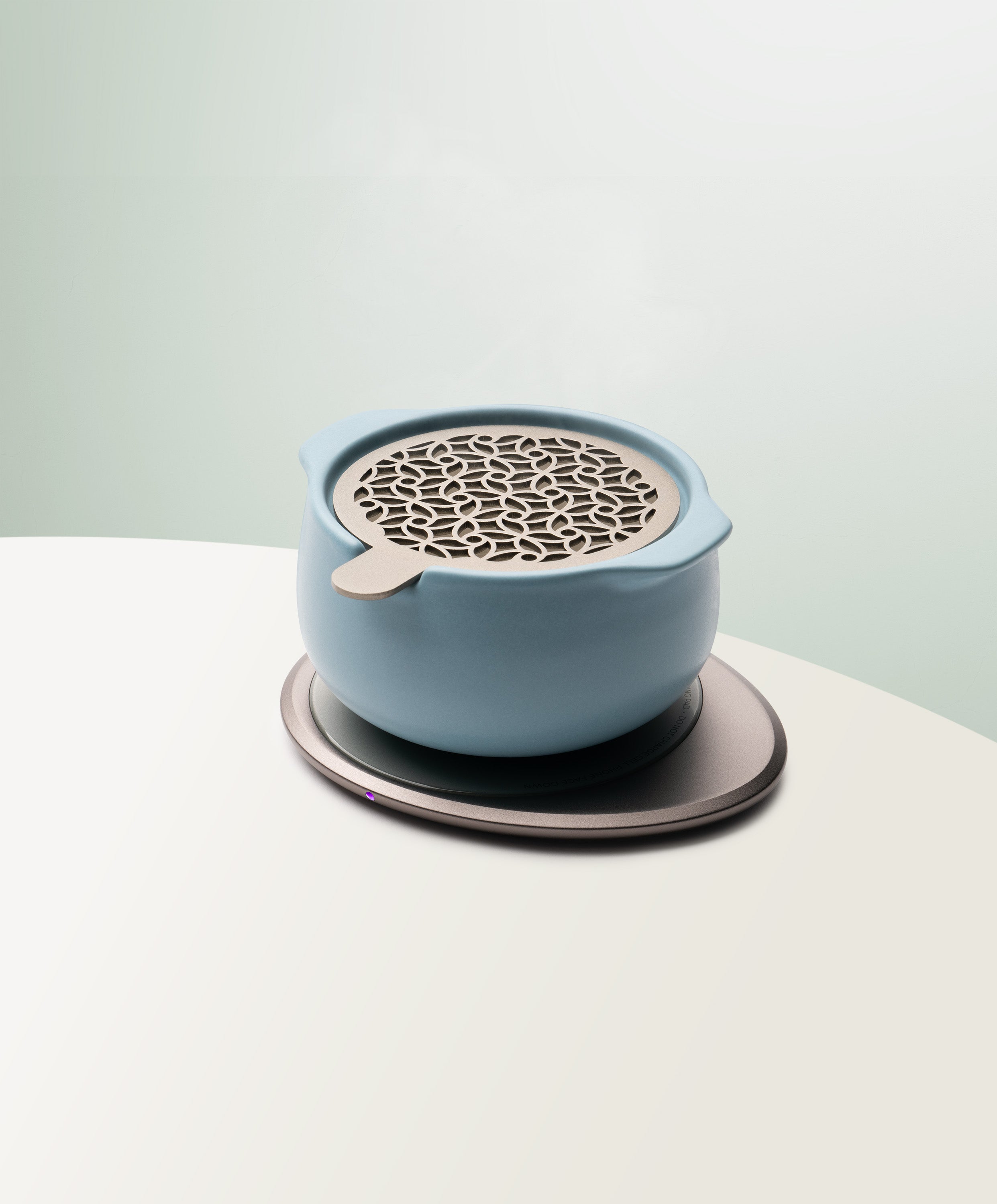 Jun Self-Heating Ceramic Diffuser 5 fl oz / 150 mL with lid in Moonmist Blue angled view on Ohom Pad 3