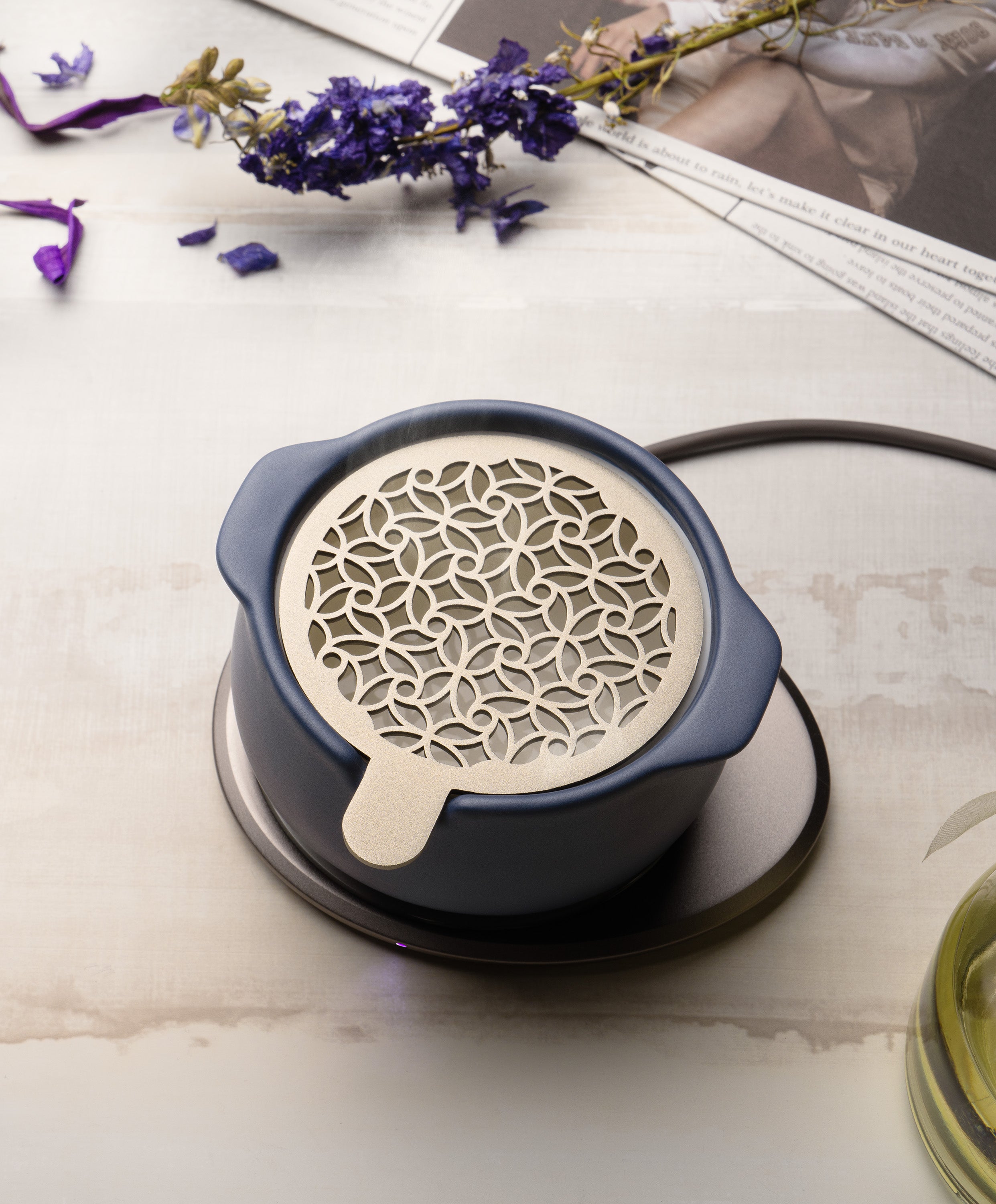 Jun self-heating ceramic diffuser 5 fl oz / 150 mL in Deep Navy with lid on charging on OHOM Pad 3