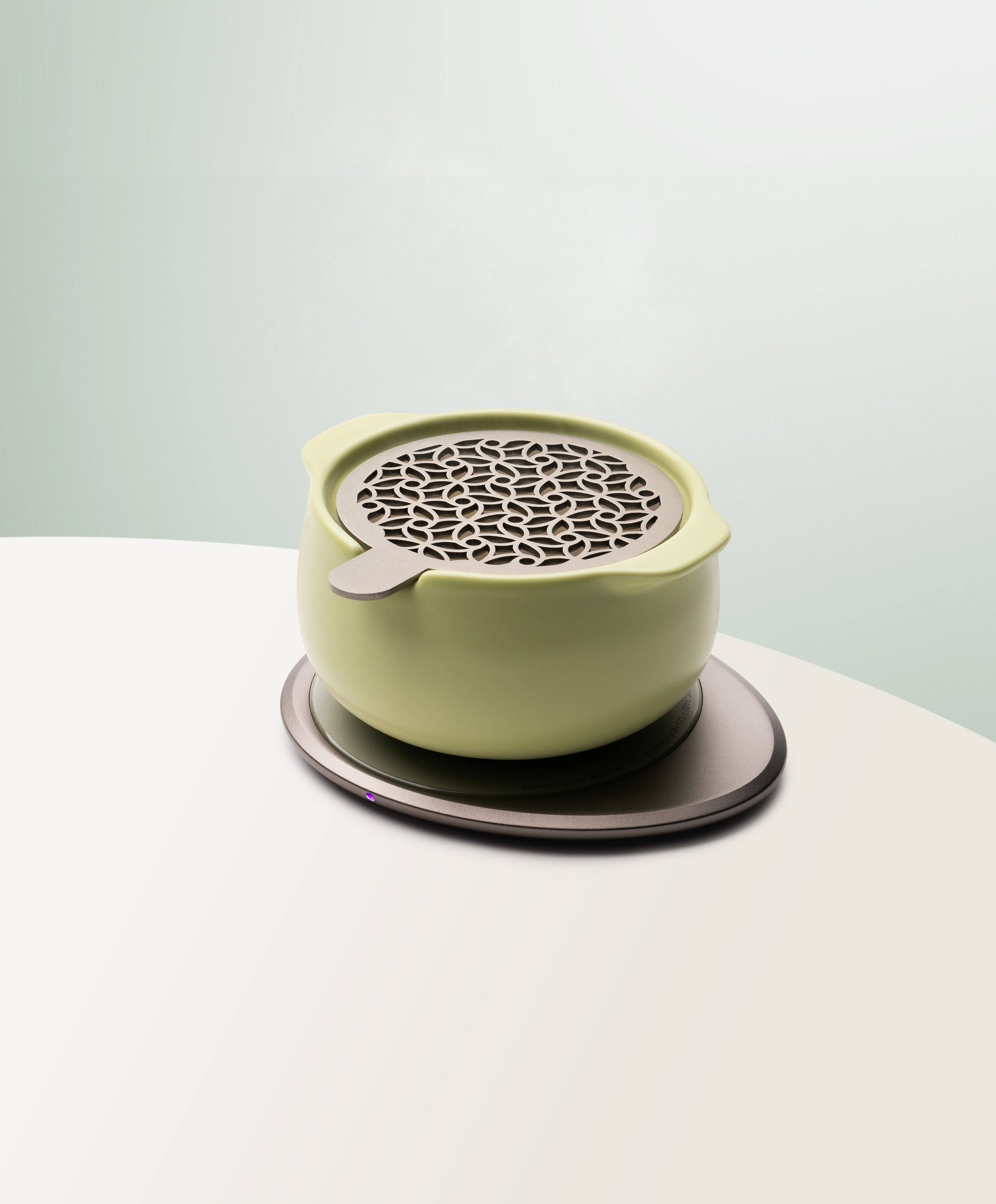 Jun Self-Heating Ceramic Diffuser 5 fl oz / 150 mL with lid in Verde Green angled view on Ohom Pad 3