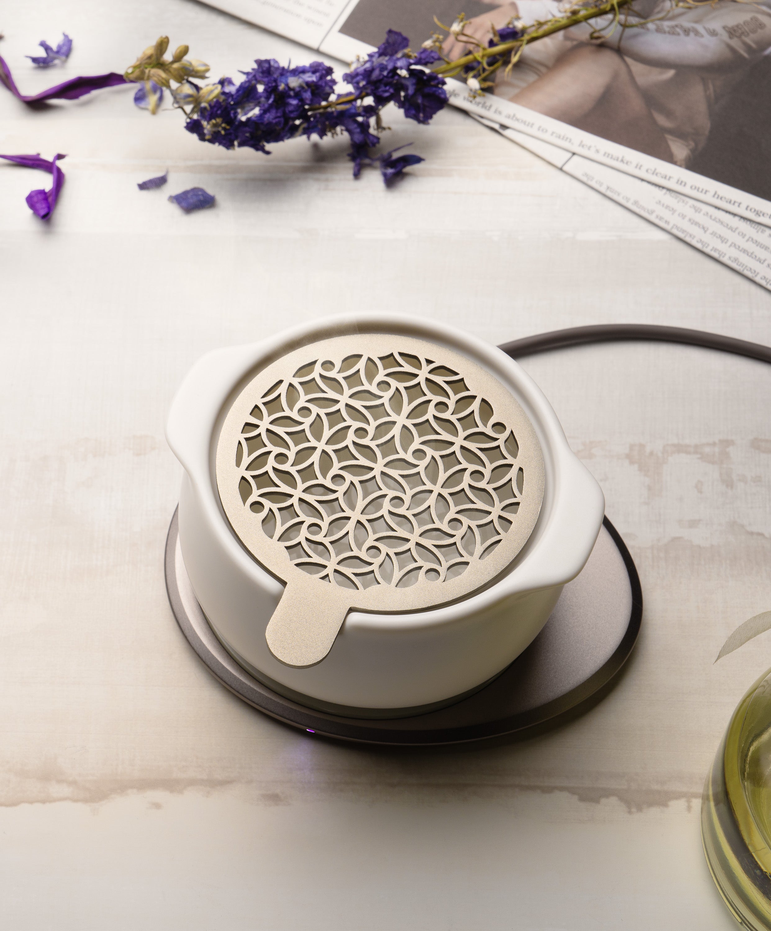 Jun self-heating ceramic diffuser 5 fl oz / 150 mL in Jasmine White with lid on charging on OHOM Pad 3