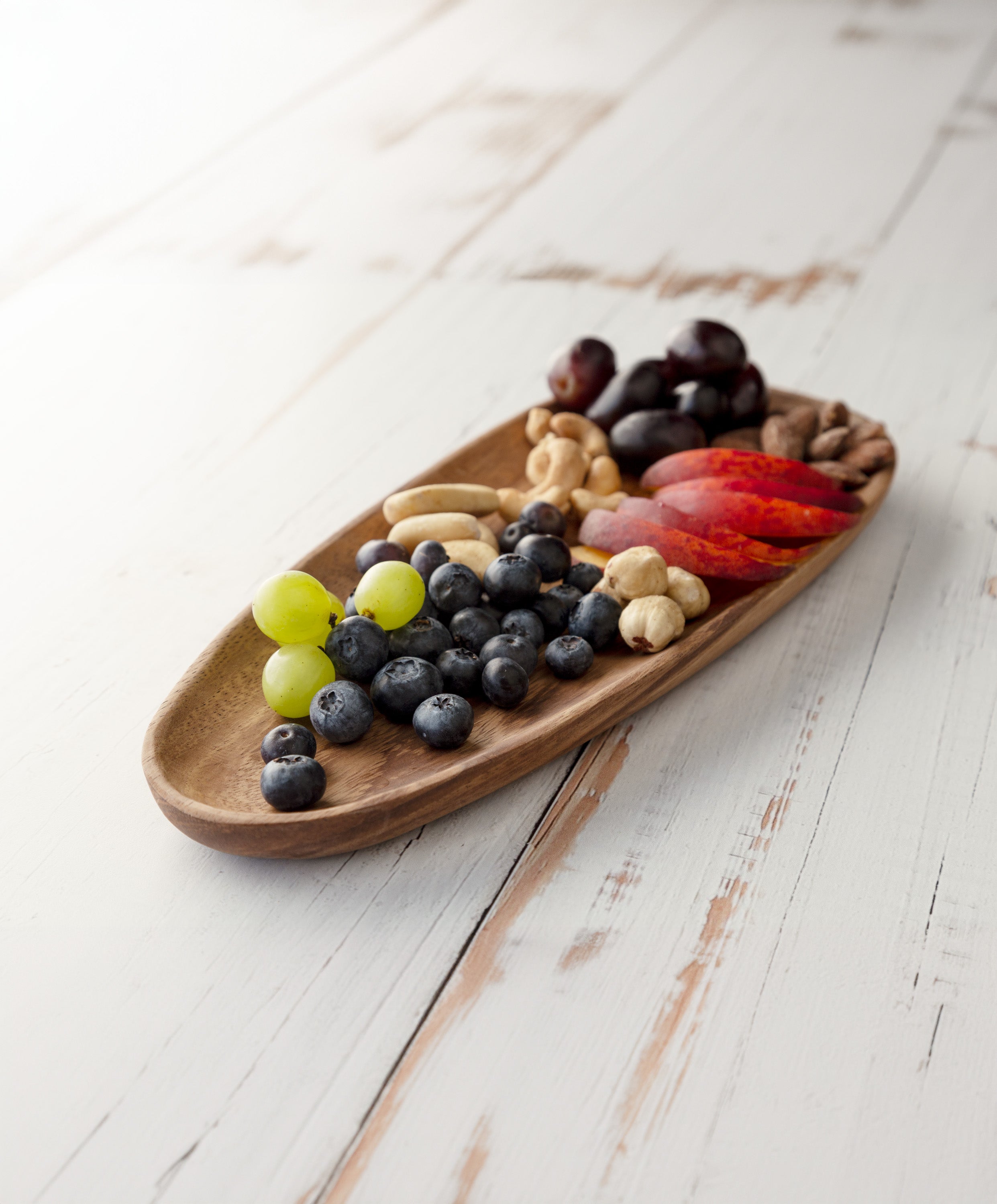 Foree wooden long plate handcrafted from solid Acacia wood 11.9 x 4.9 in / 30 x 12.5 cm with blueberries, grapes, apples, and nuts on top