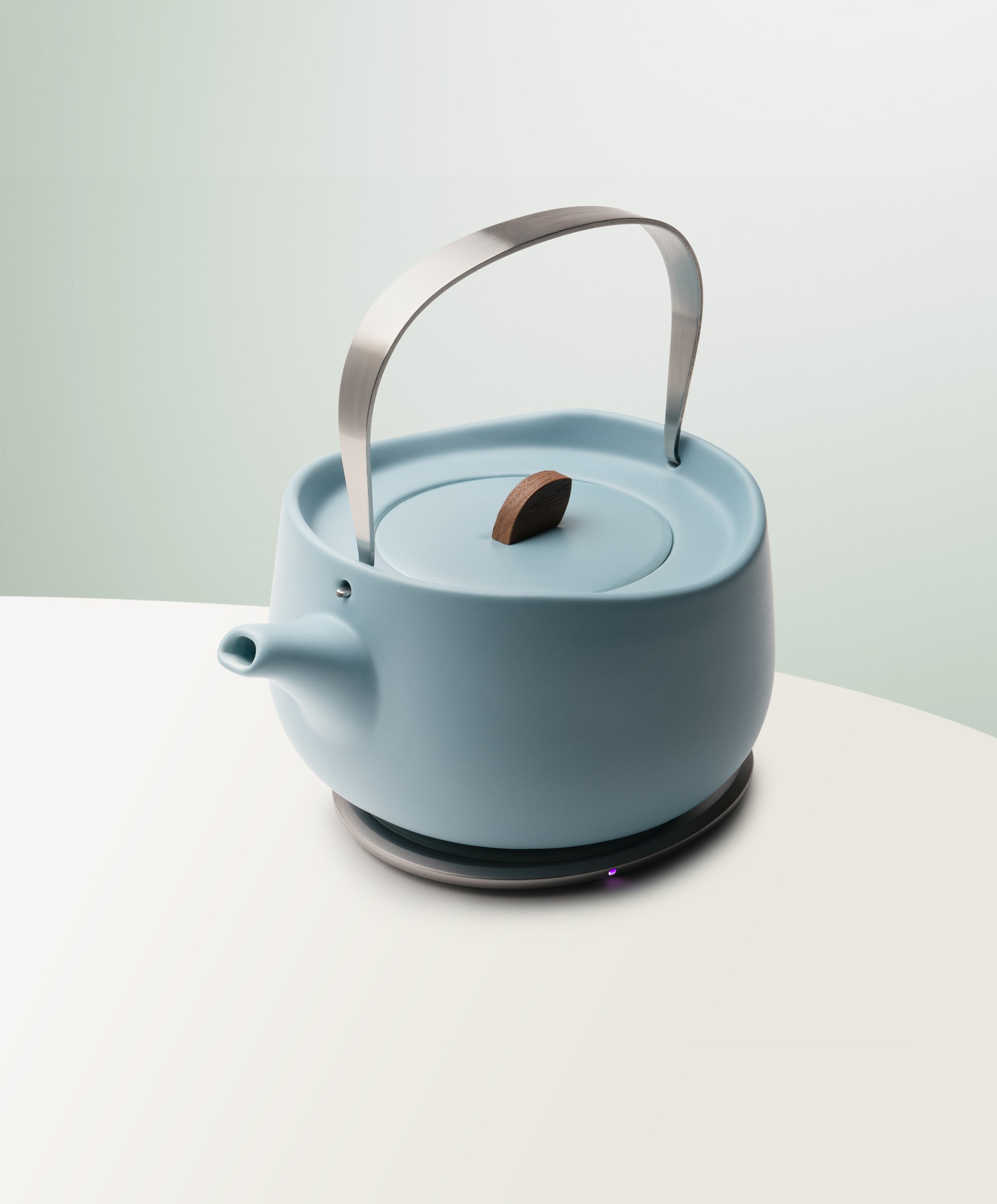 Leiph Self-Heating Ceramic Teapot Set 20 fl oz / 600 mL in Moonmist Blue angled top-side view on OHOM Charging Pad 3