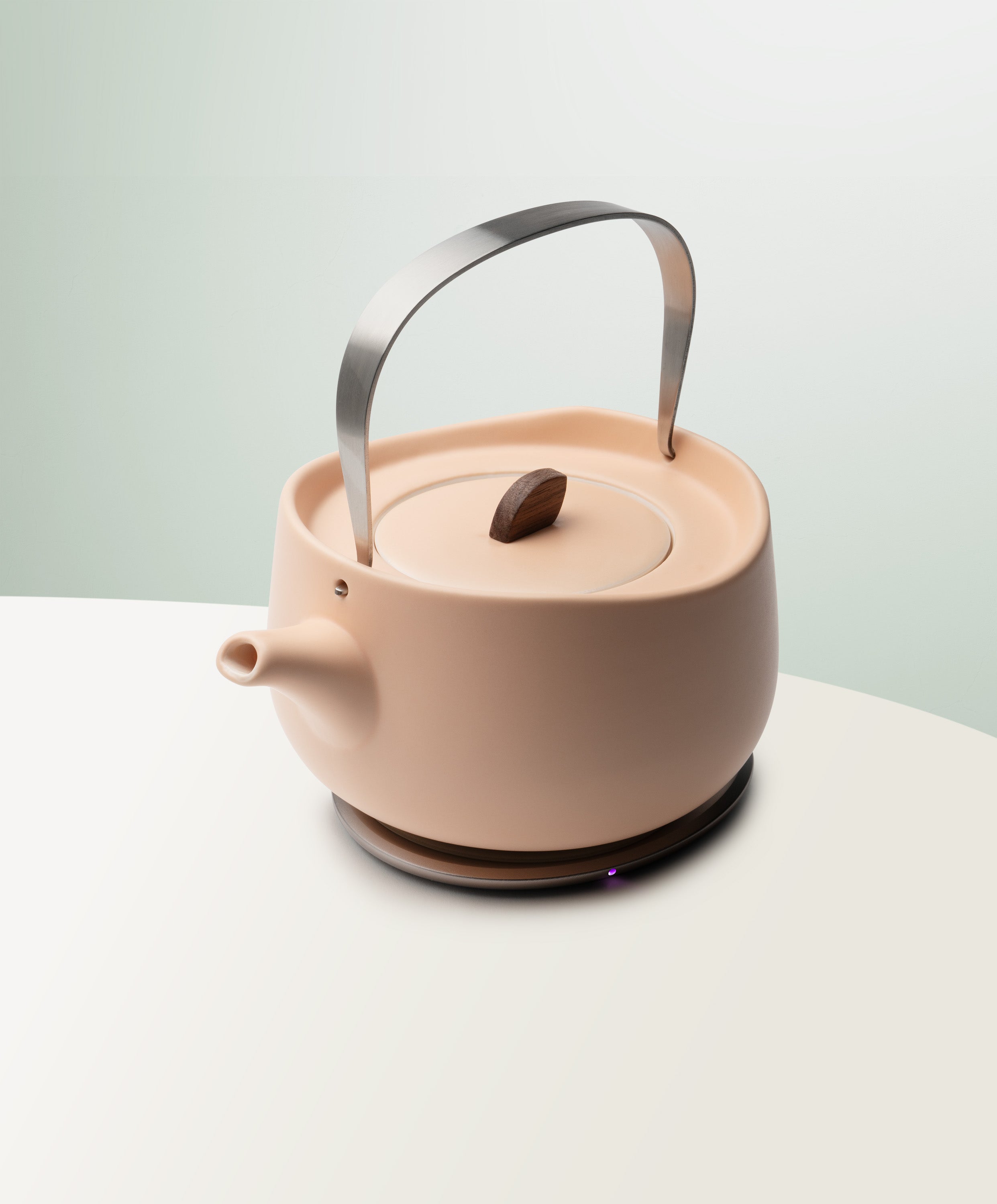 Leiph Self-Heating Ceramic Teapot Set 20 fl oz / 600 mL in Rosy Apricot angled top-side view on OHOM Charging Pad 3