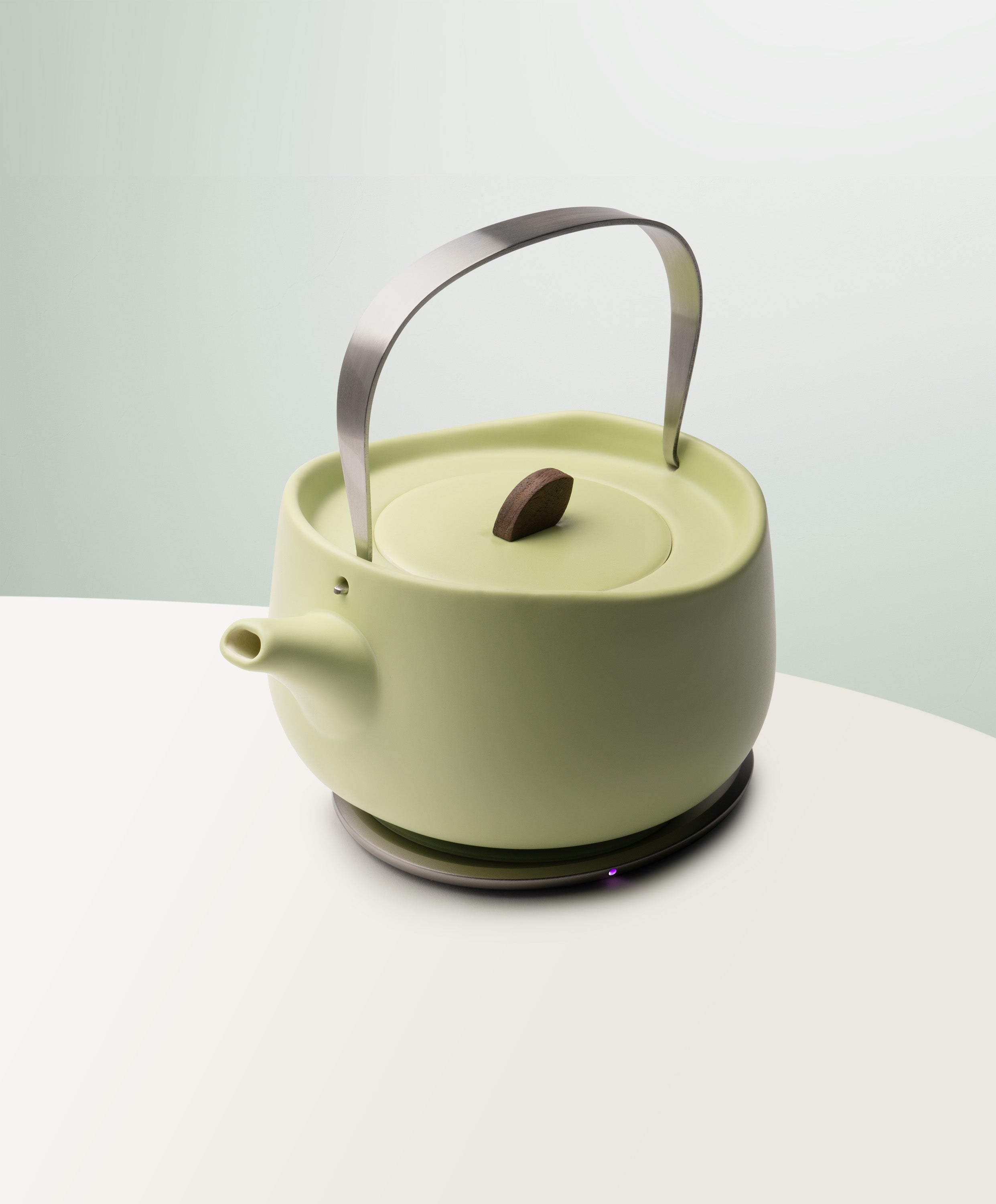 Leiph Self-Heating Ceramic Teapot Set 20 fl oz / 600 mL in Verde Green angled top-side view on OHOM Charging Pad 3