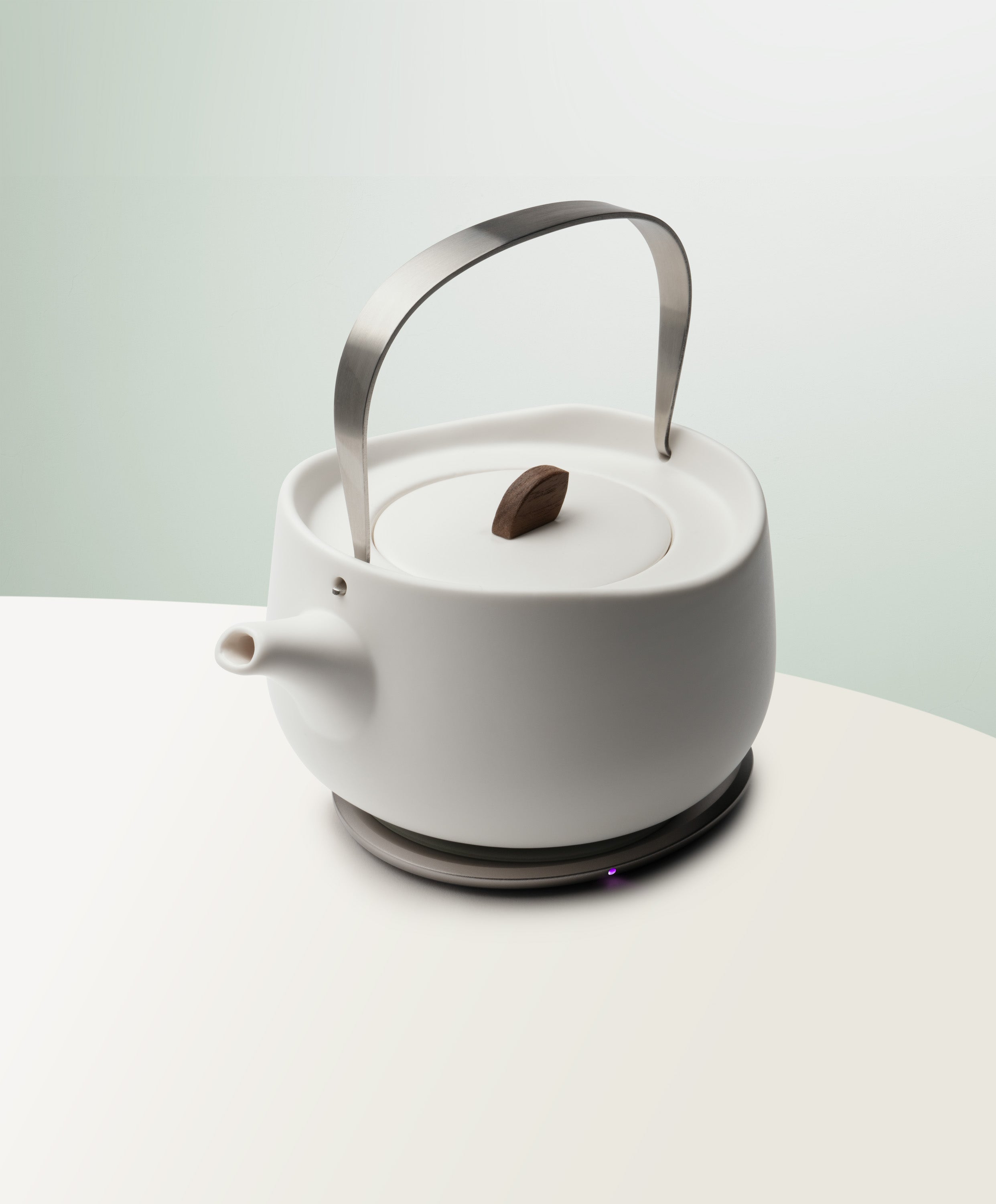 Leiph Self-Heating Ceramic Teapot Set 20 fl oz / 600 mL in Jasmine White angled top-side view on OHOM Charging Pad 3