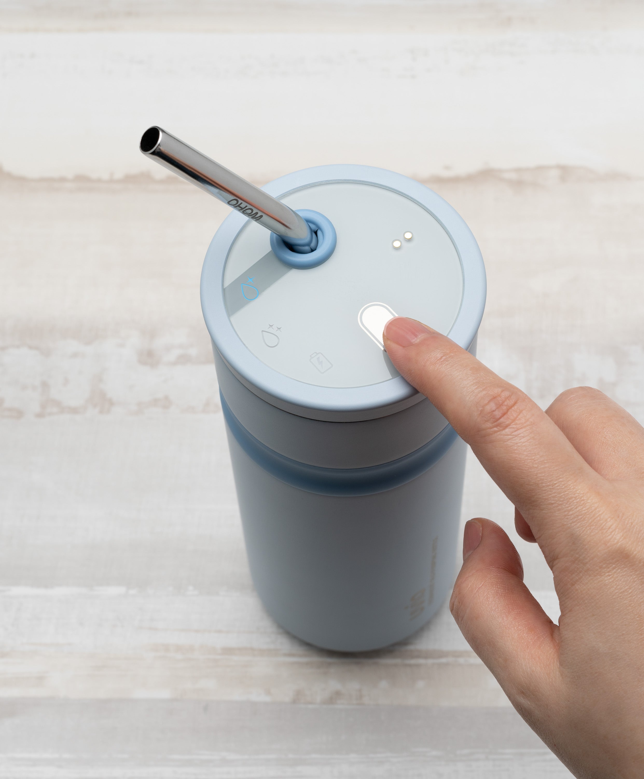 Person pressing button on Uvio self-purifying water bottle 16 fl oz / 480 mL in Polar Blue to activate UV-C purification