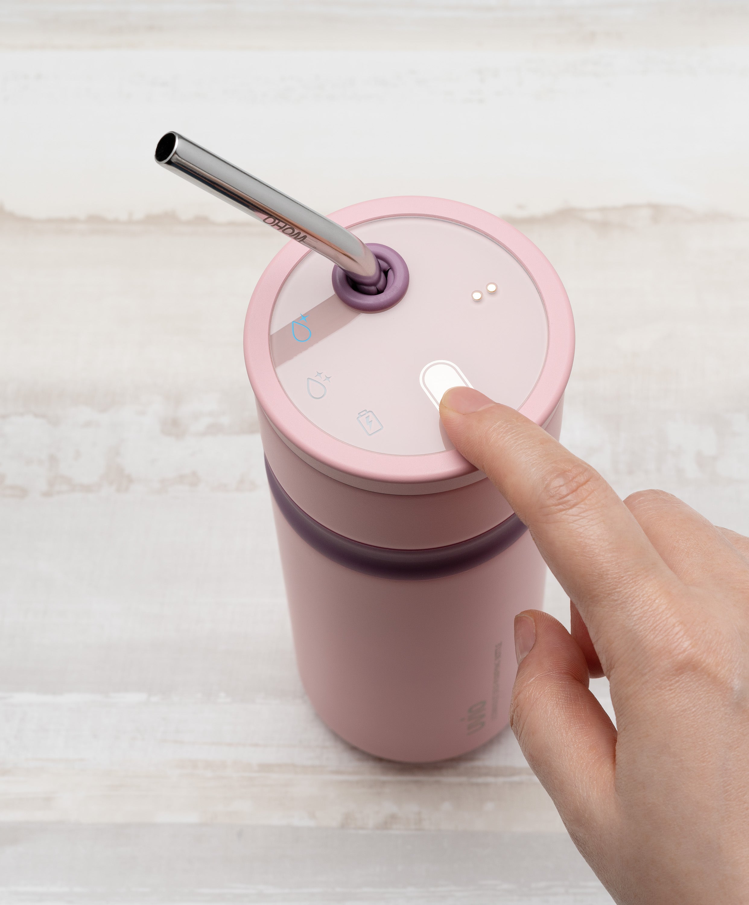 Person pressing button on Uvio self-purifying water bottle 16 fl oz / 480 mL in April Blush to activate UV-C purification