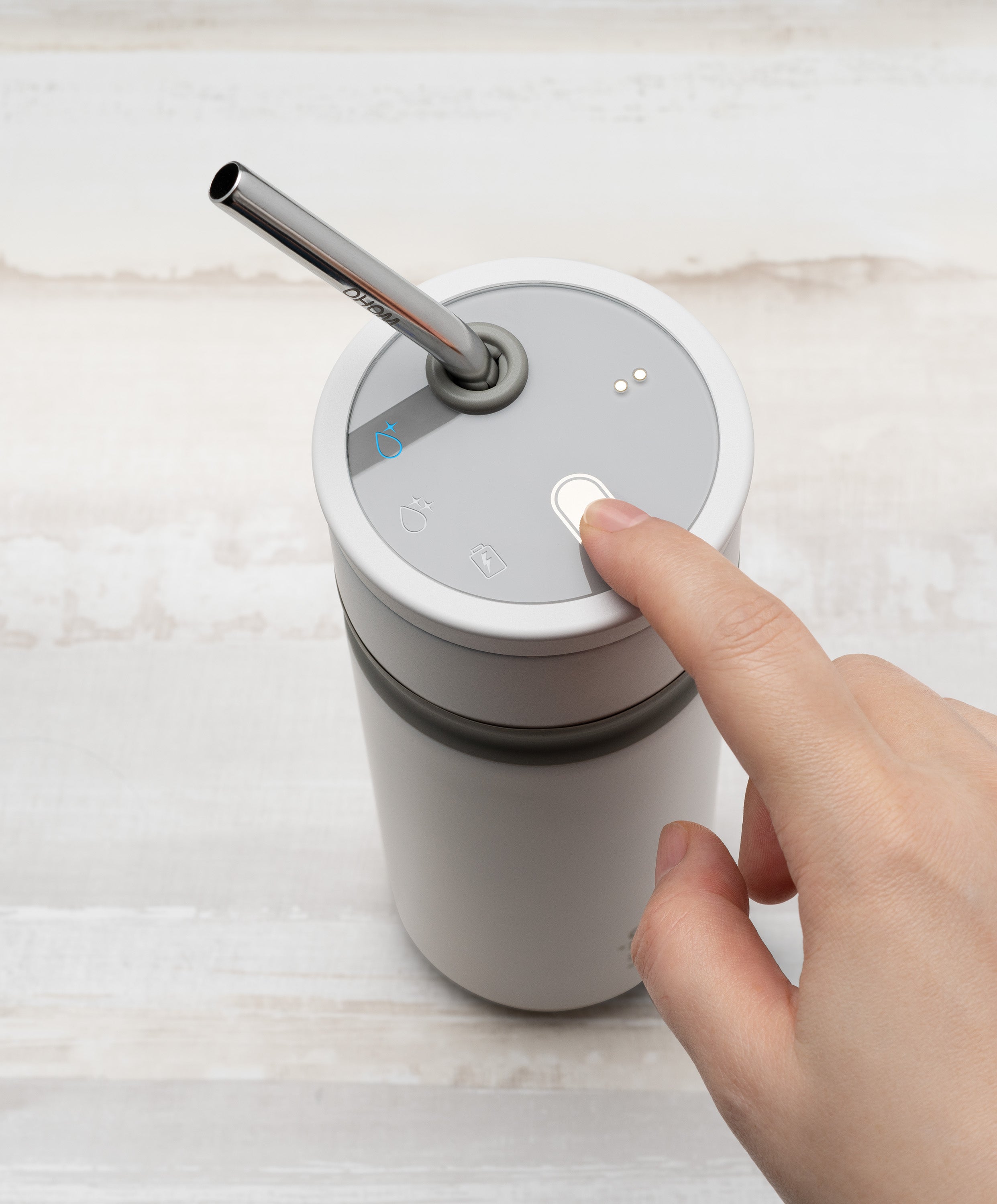 Person pressing button on Uvio self-purifying water bottle 16 fl oz / 480 mL in stainless steel to activate UV-C purification