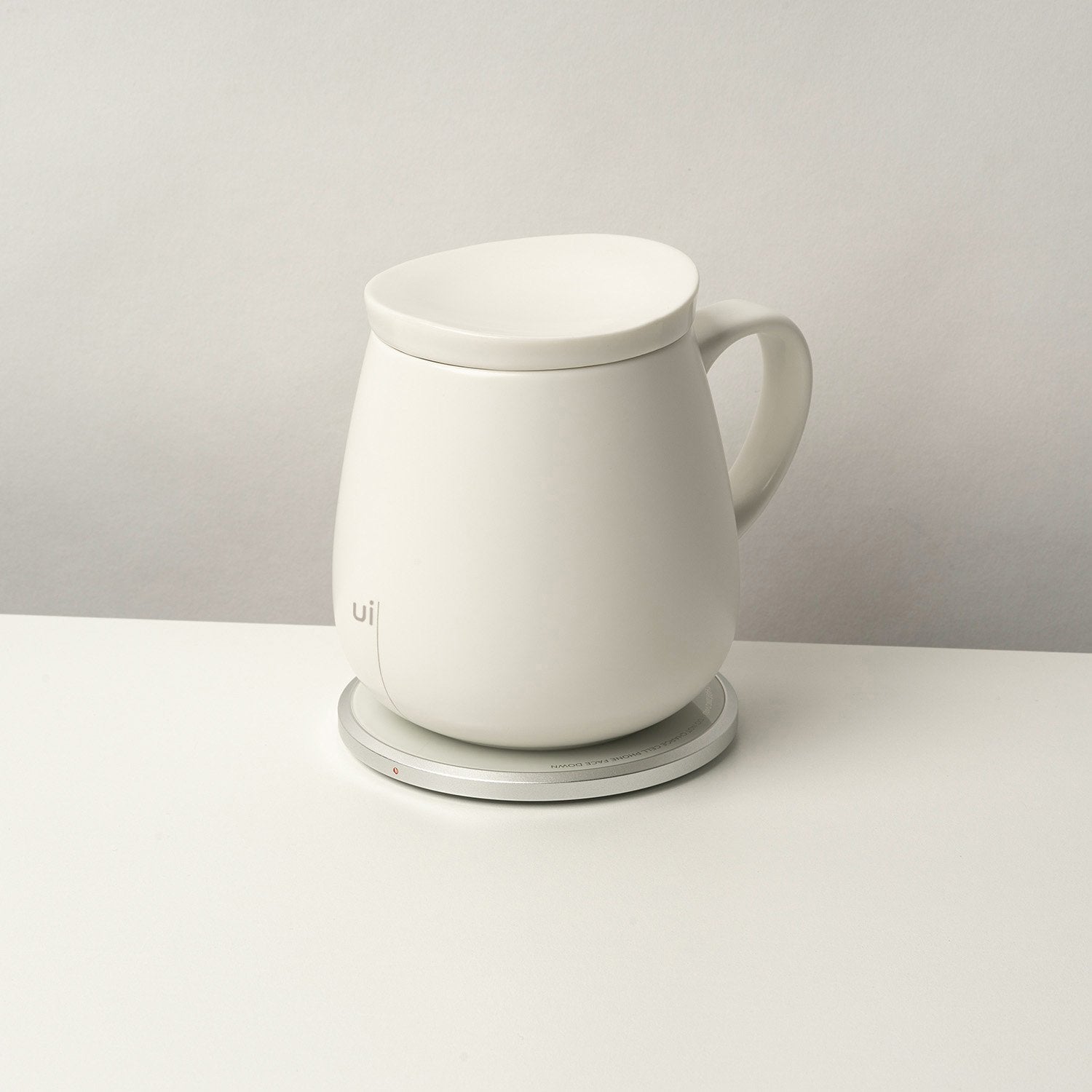 Large white mug with lid on heating pad