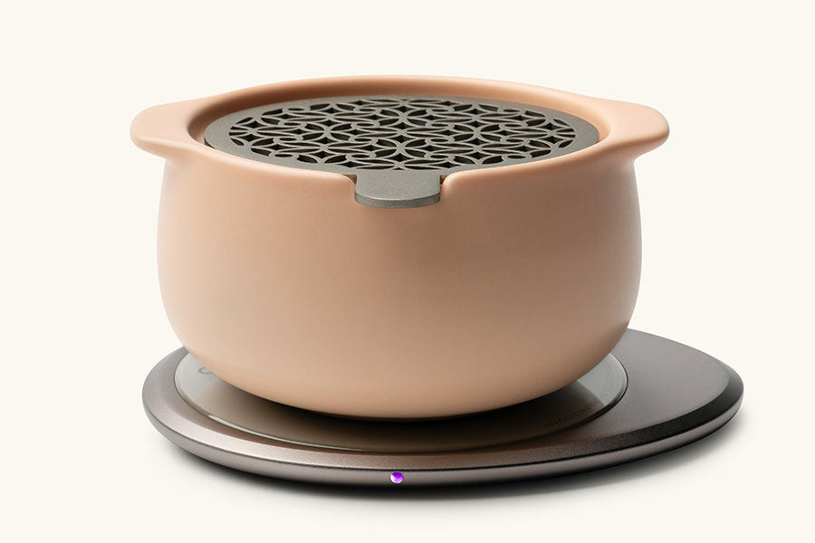 Jun Self-Heating Ceramic Diffuser 5 fl oz / 150 mL in Rosy Apricot with lid on Ohom Pad 3