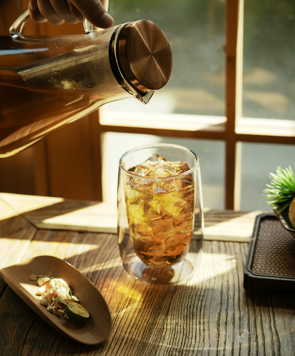 Person pouring iced tea from Sio Cold-Infusion Pitcher into Sio dual-wall glass 8 fl oz / 236 mL made from fine quality borosilicate glass.