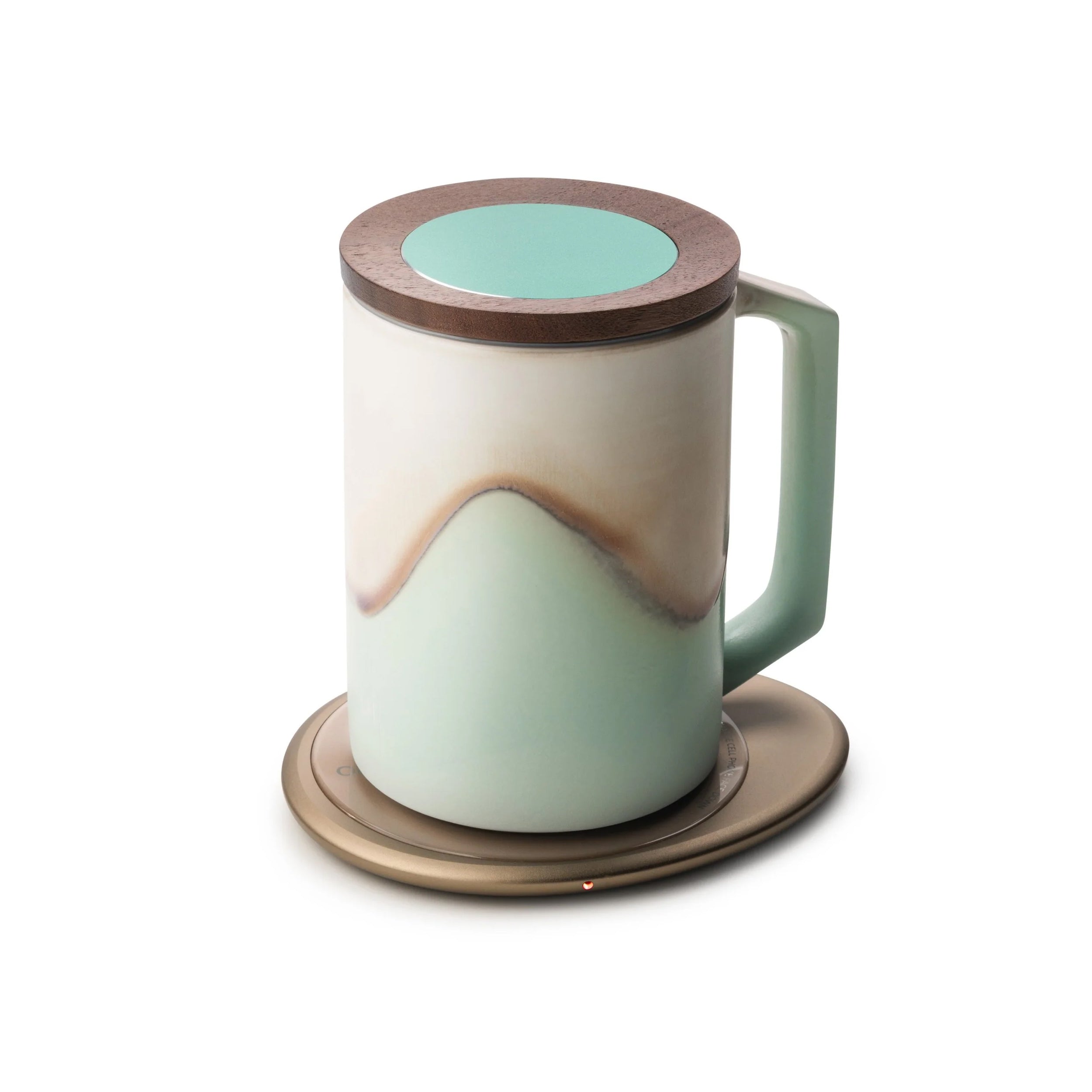 Mint colored mug with lid and design on top of pink pebble heating pad