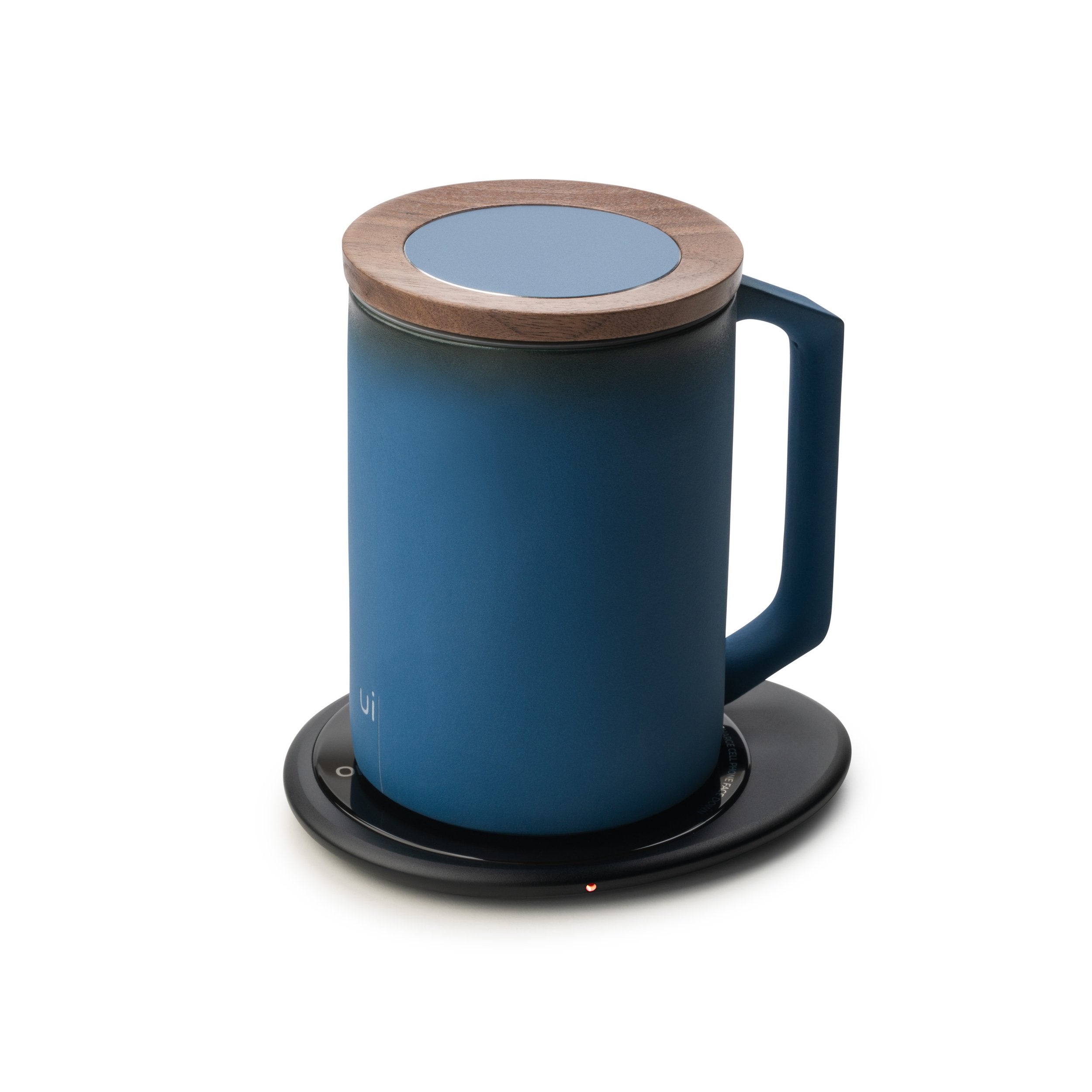Dark blue mug with lid on black pebble heating pad