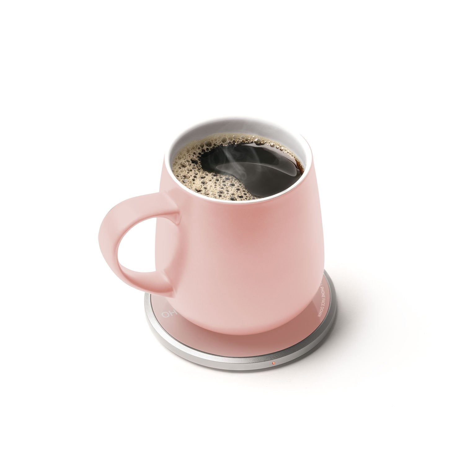 Pink mug with tea on heating pad