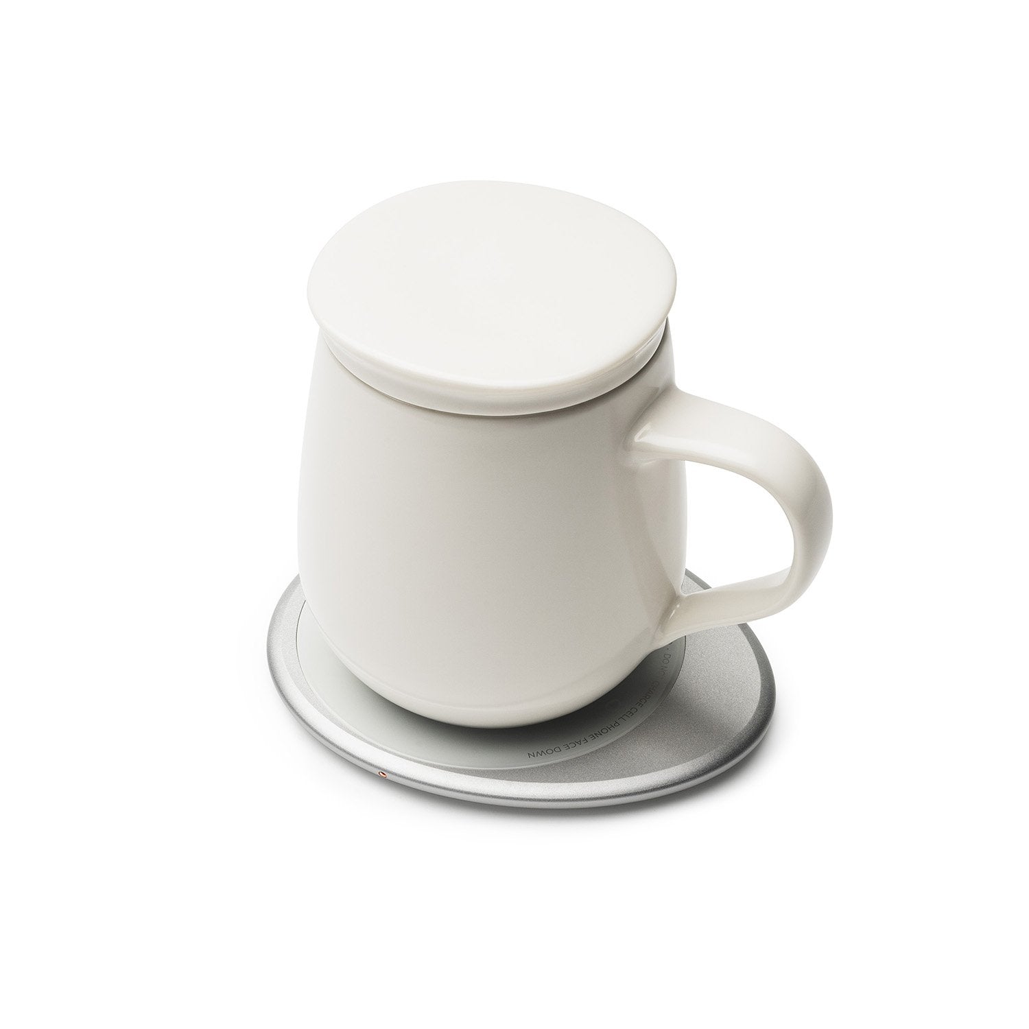 White mug with lid on white pebble heating pad