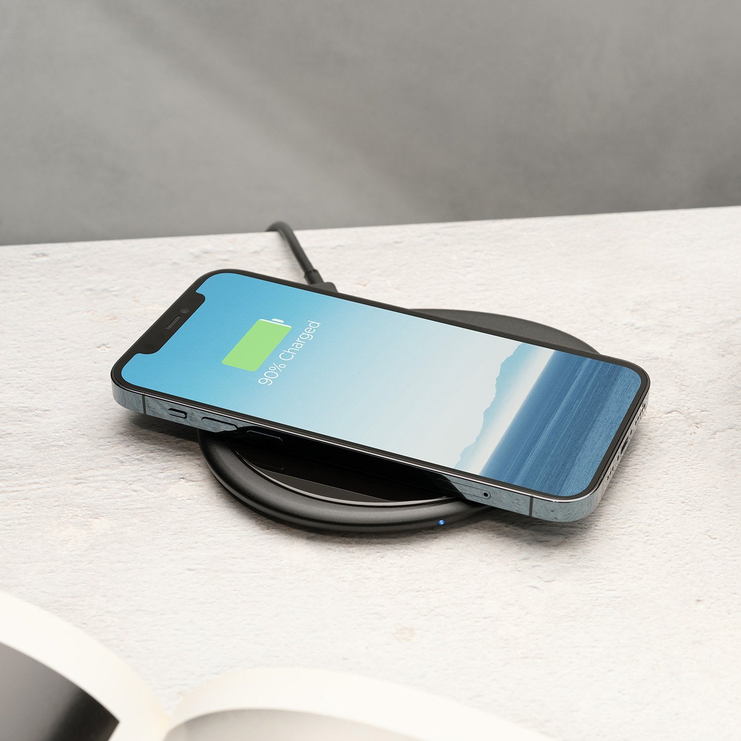 Phone on black pebble charging pad