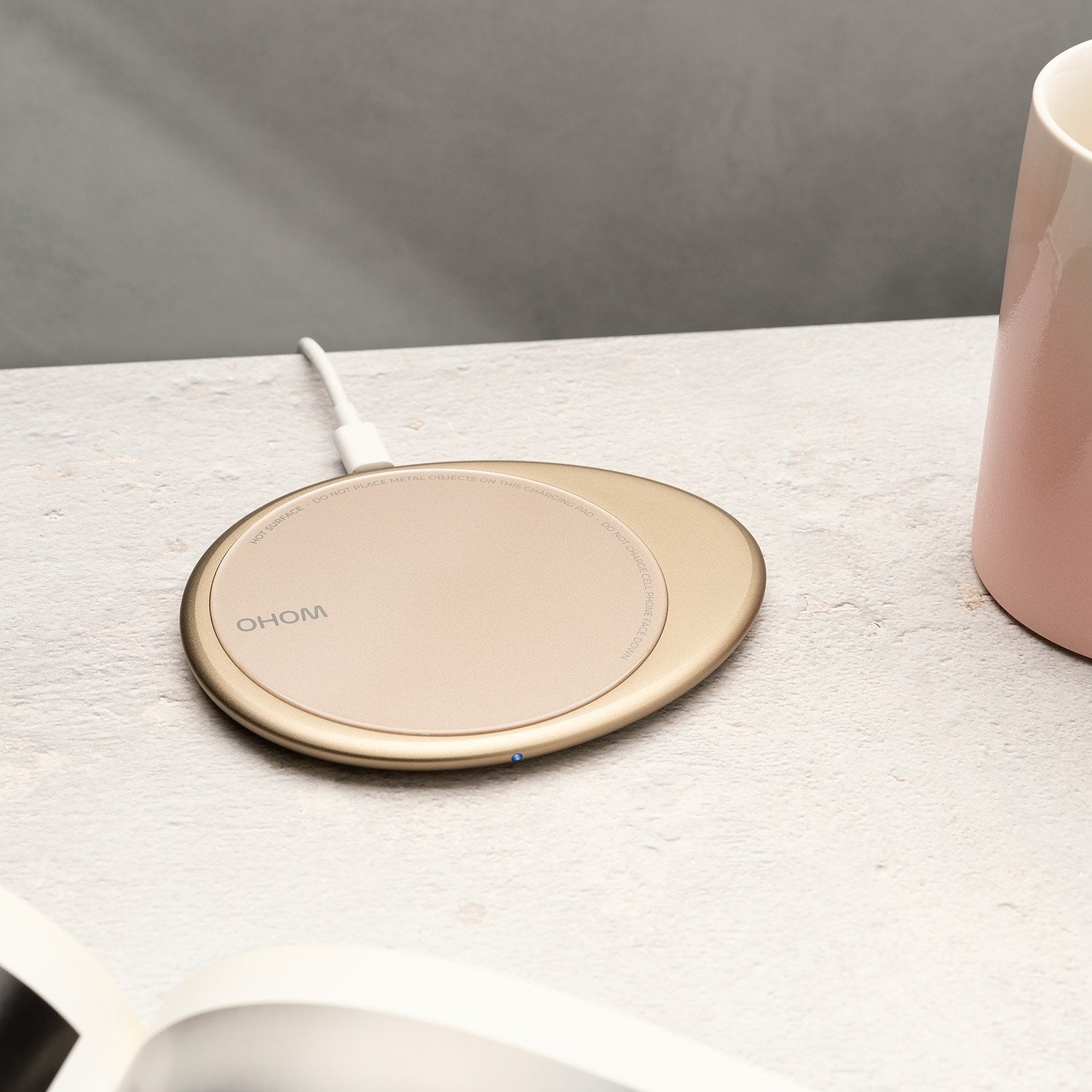 Pink pebble charging pad next to pink mug with design