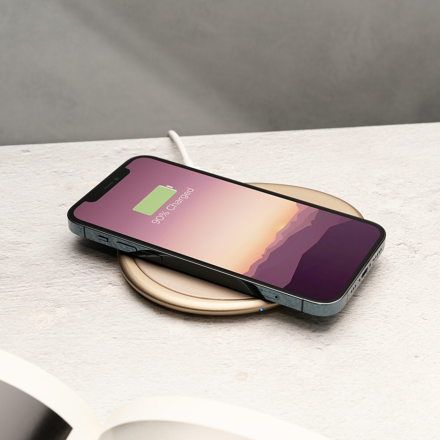 Phone on pink pebble charging pad