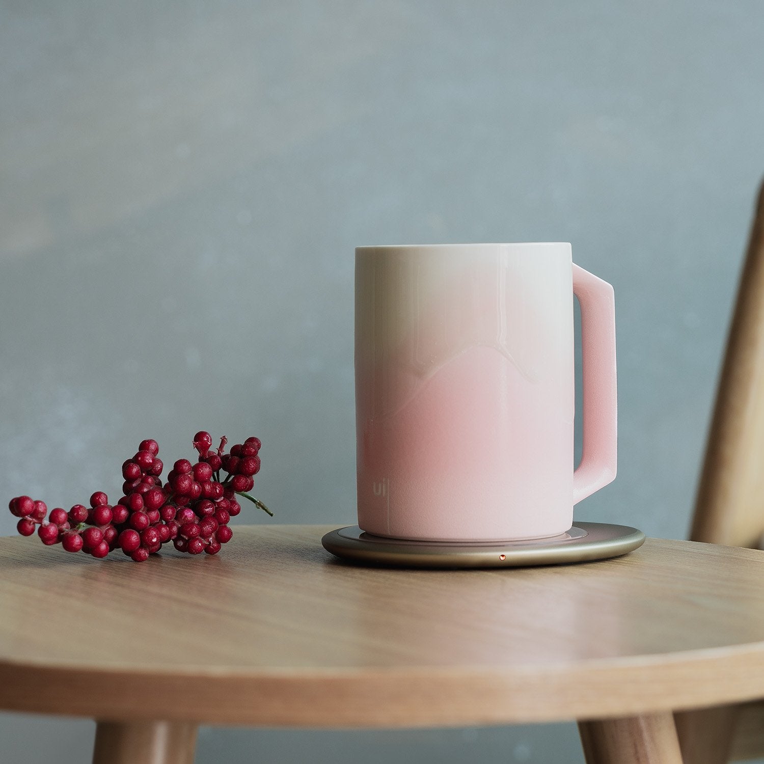 Pink mug with design on heating pad on table