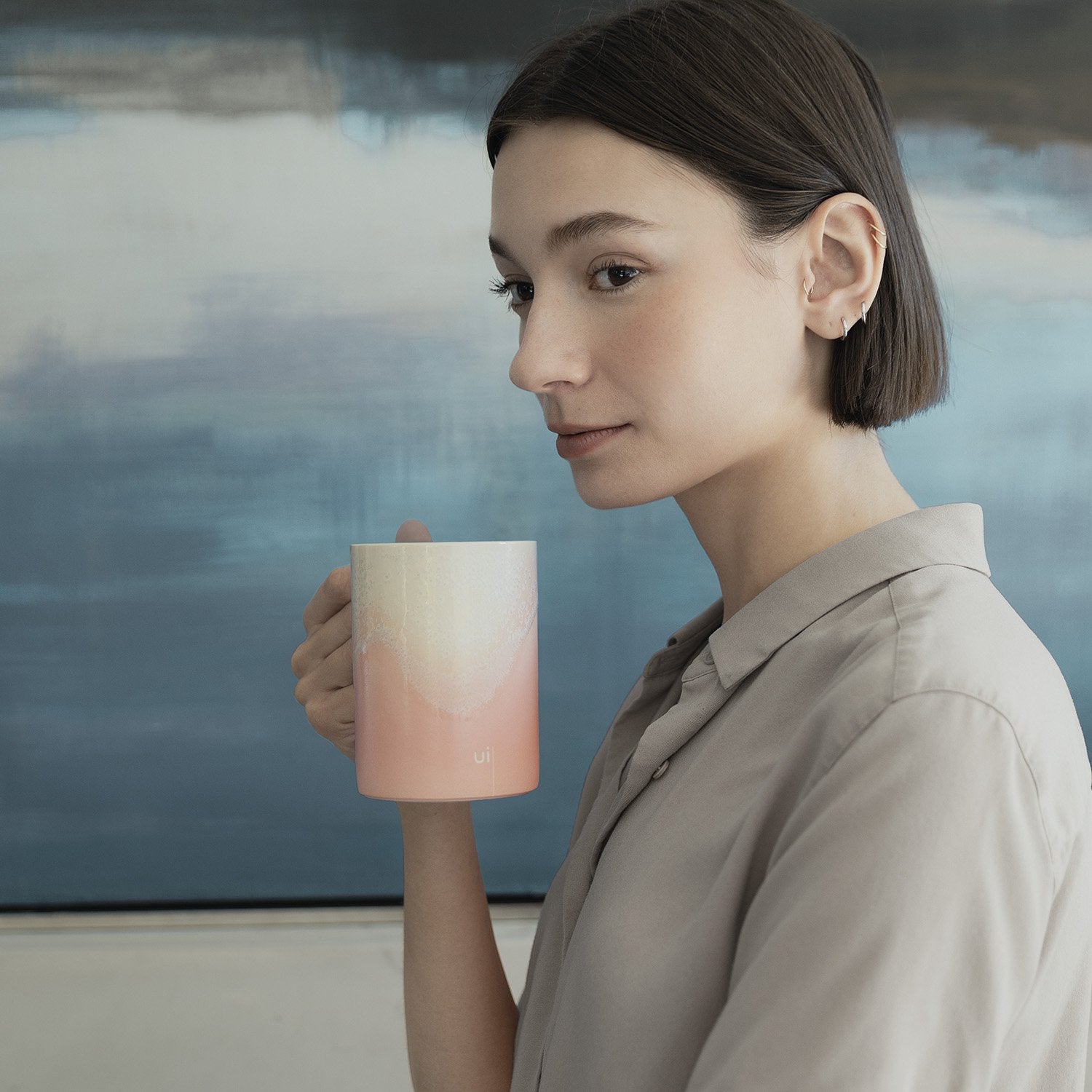 Woman holding pink mug with design